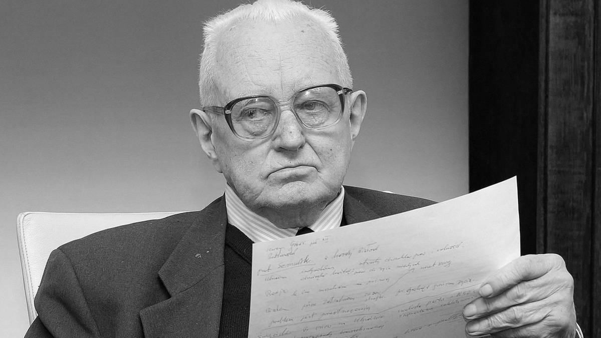 Літній чоловік в окулярах сидить у кріслі й тримає аркуш із рукописом