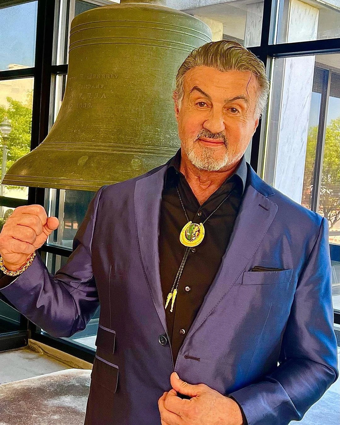 Sylvester Stallone w granatowej marynarce z medalem przy szyi
