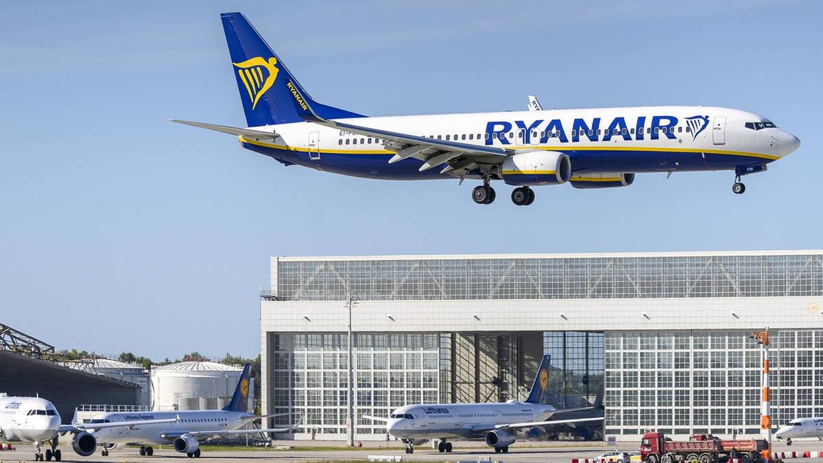 Літак Ryanair із випущеним шасі пролітає над терміналом і літаками Lufthansa