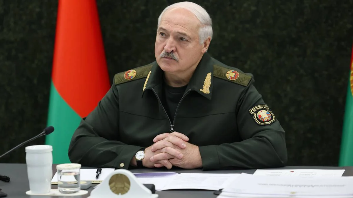 Лукашенко у військовій формі сидить за столом на тлі прапорів Білорусі