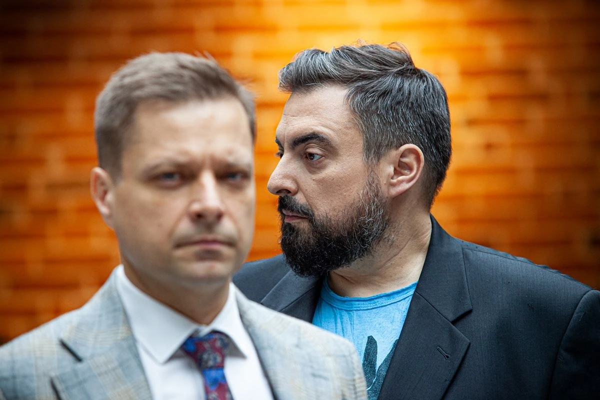 Двоє чоловіків у офіційному одязі розмовляють у залі суду